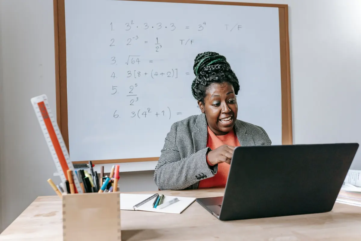 Tutor teaching maths online in front of a whiteboard
