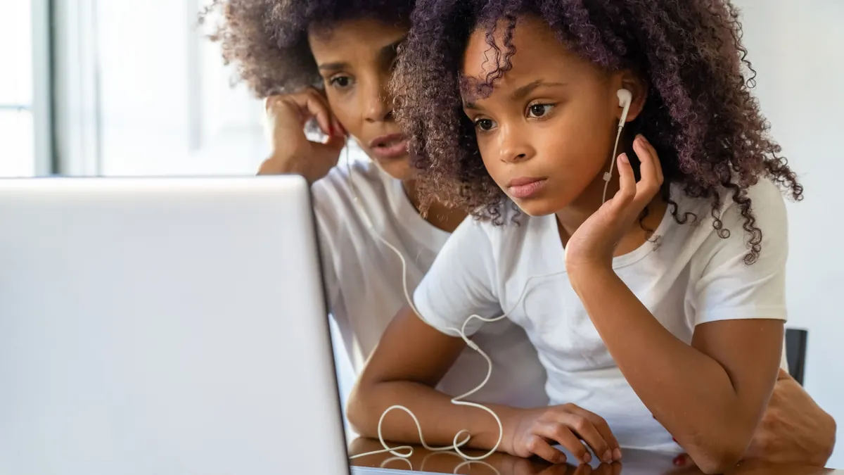 Parent and child learning together at a laptop
