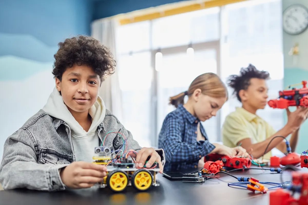 Child proudly holding a robot car they built